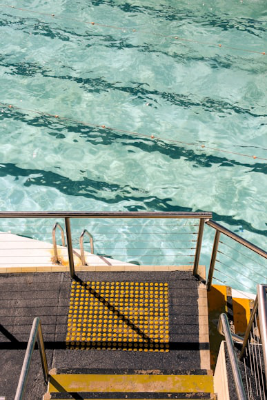 Black and gray metal pool fence with stairs