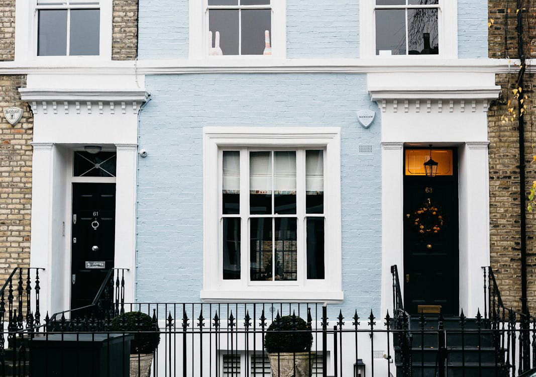 A classic residential building facade featuring an elegant metal fence.