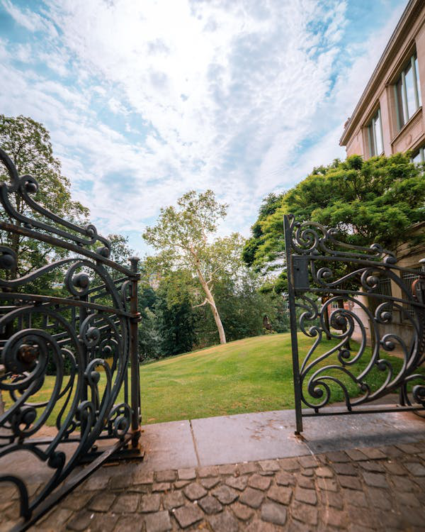 Opened metal gate leading to a modern building.