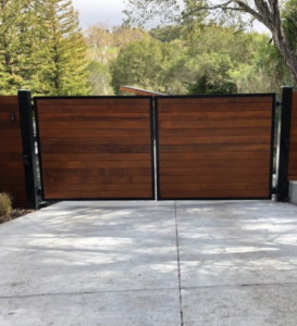  A custom driveway gate made from wood and metal frame.