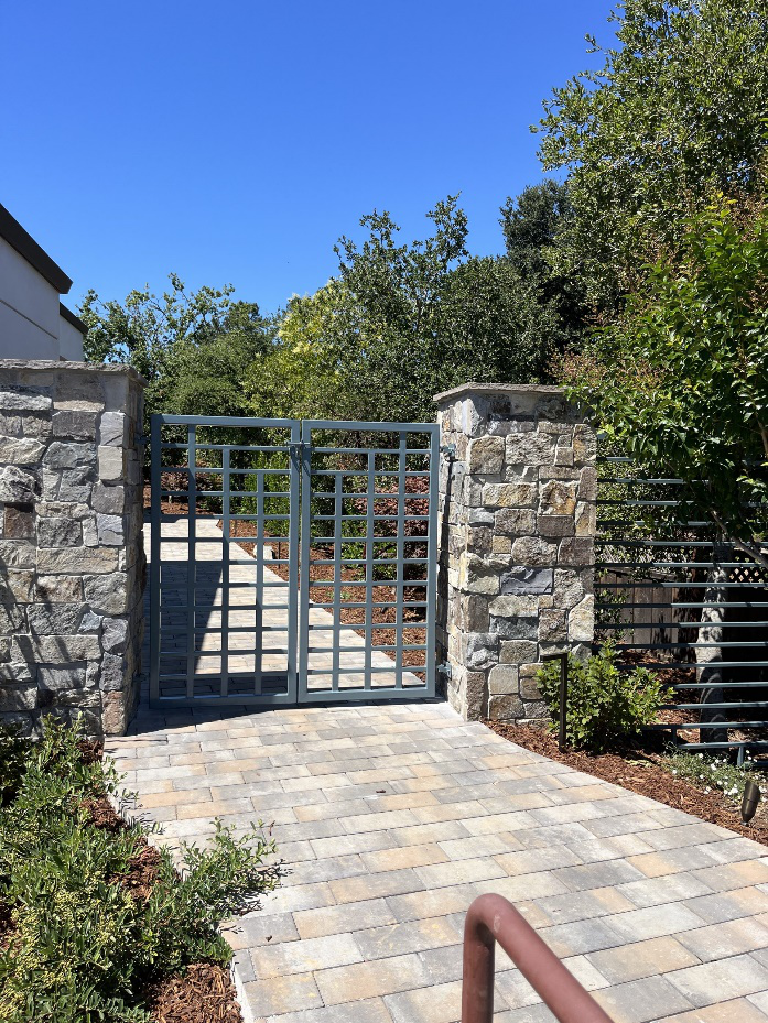 A colored metal driveway gate and fence.