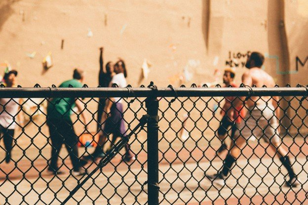 A playground with a metal chain link fence for secure enclosure. 