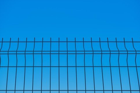 Metal fence with a clear blue sky in the background.